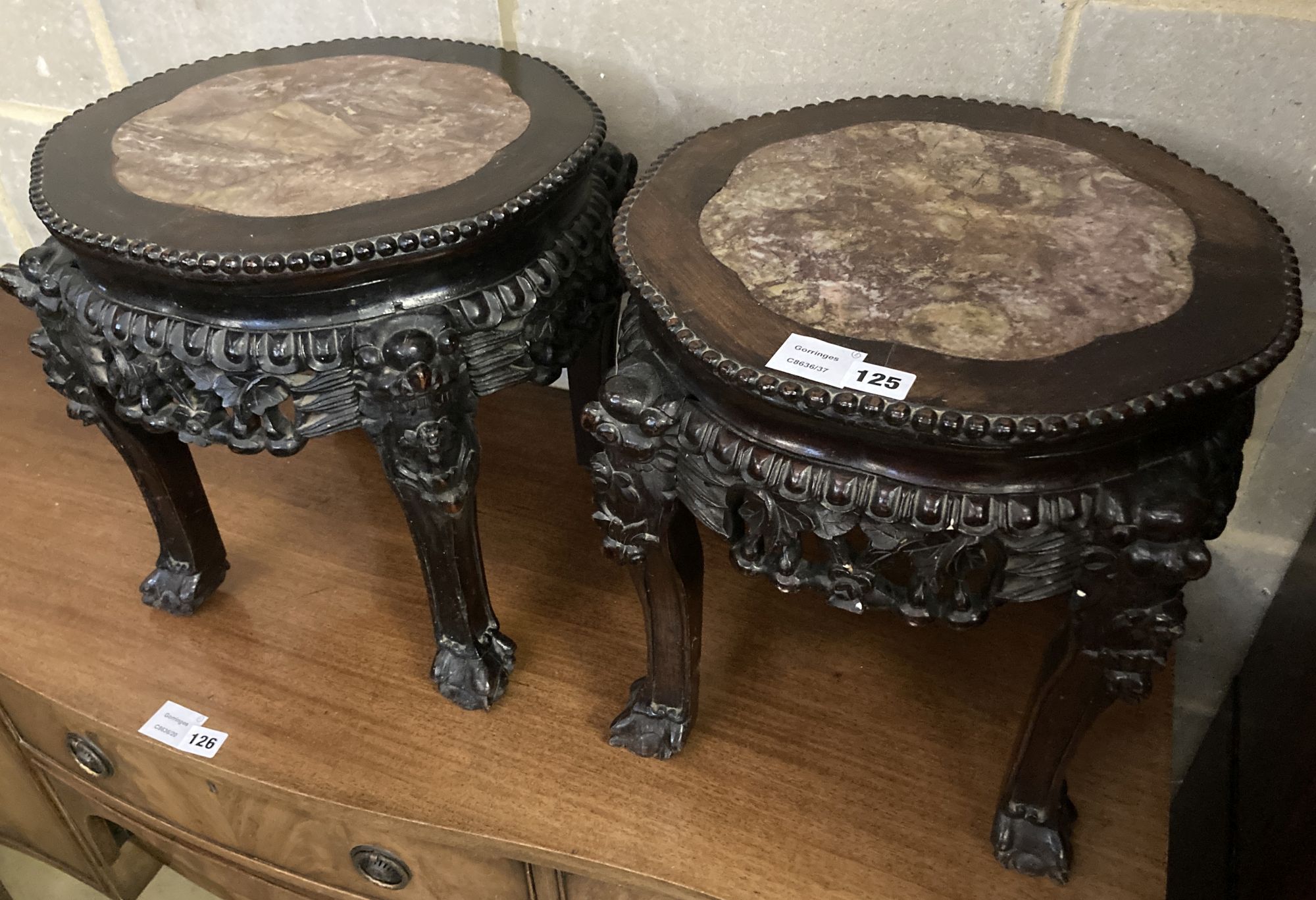 A pair of circular Chinese carved hardwood jardiniere stands, with rouge marble inset tops, 38cm diameter, height 38cm